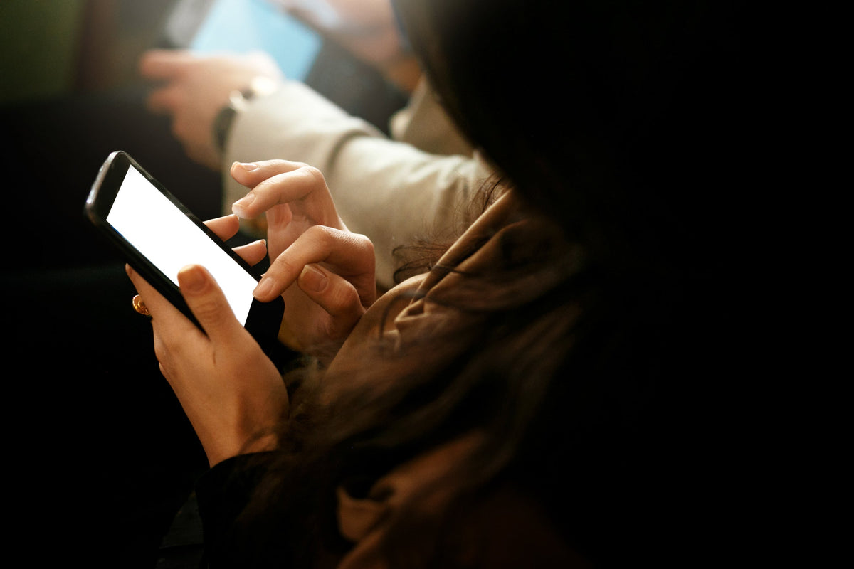 Close-up of hands holding a phone and scrolling